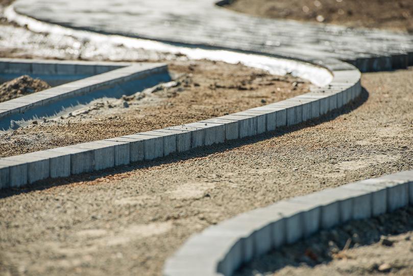 A newly installed concrete curb along a residential street