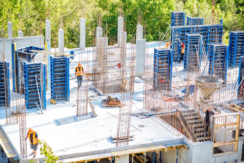 A high-rise building under construction with concrete being poured